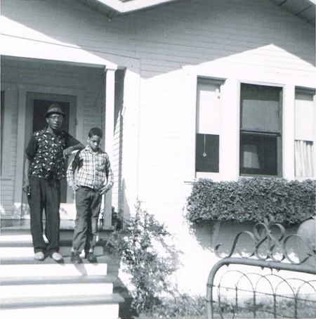 Author Walter Mosley in front of his childhood home in the LA neighborhood of Watts. He's standing with his father.
